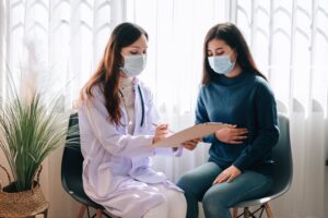 asian-doctor-visit-examines-young-adult-woman-hospital